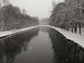 another view of the canal of the river Isar at some strong cold winter day with dancing snowflakes